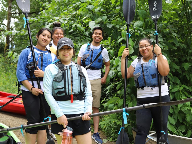 Cheerful young kayakers posing with oars