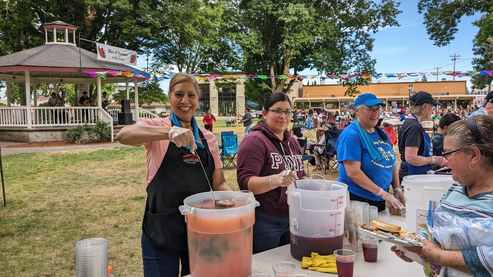 Cheerful volunteers serving horchata in a large public picnic