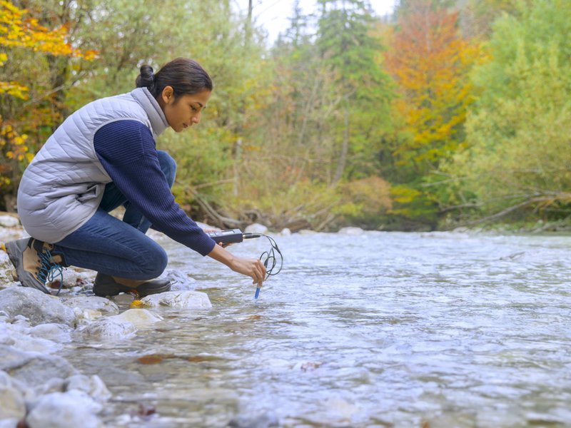 Biologist testing the PH level in a river