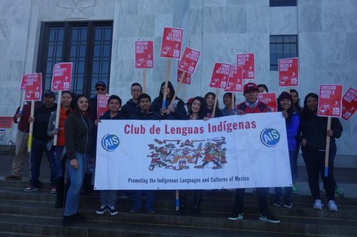 A group of people with signs on the state capitol steps