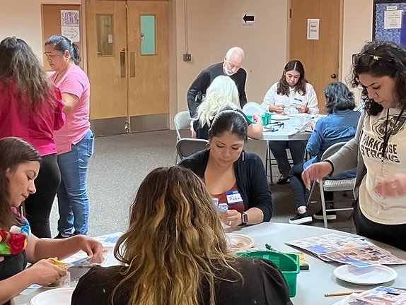 Groups of people working together at tables on art projects