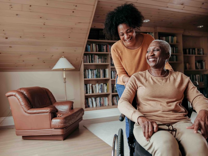 Young woman pushing an older woman in a wheelchair