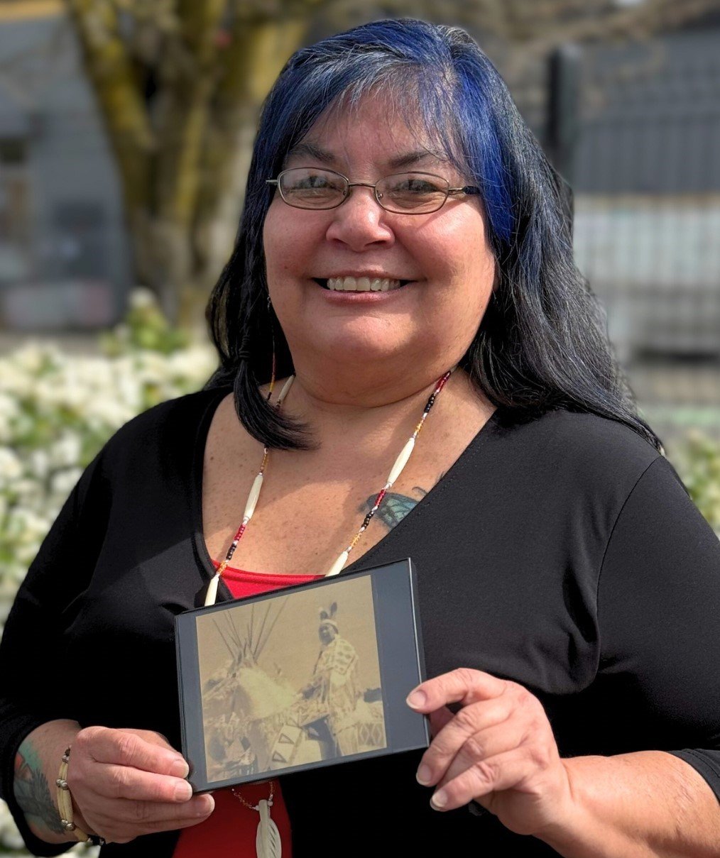 Michele Pinkham holding a photo of her grandmother in regalia