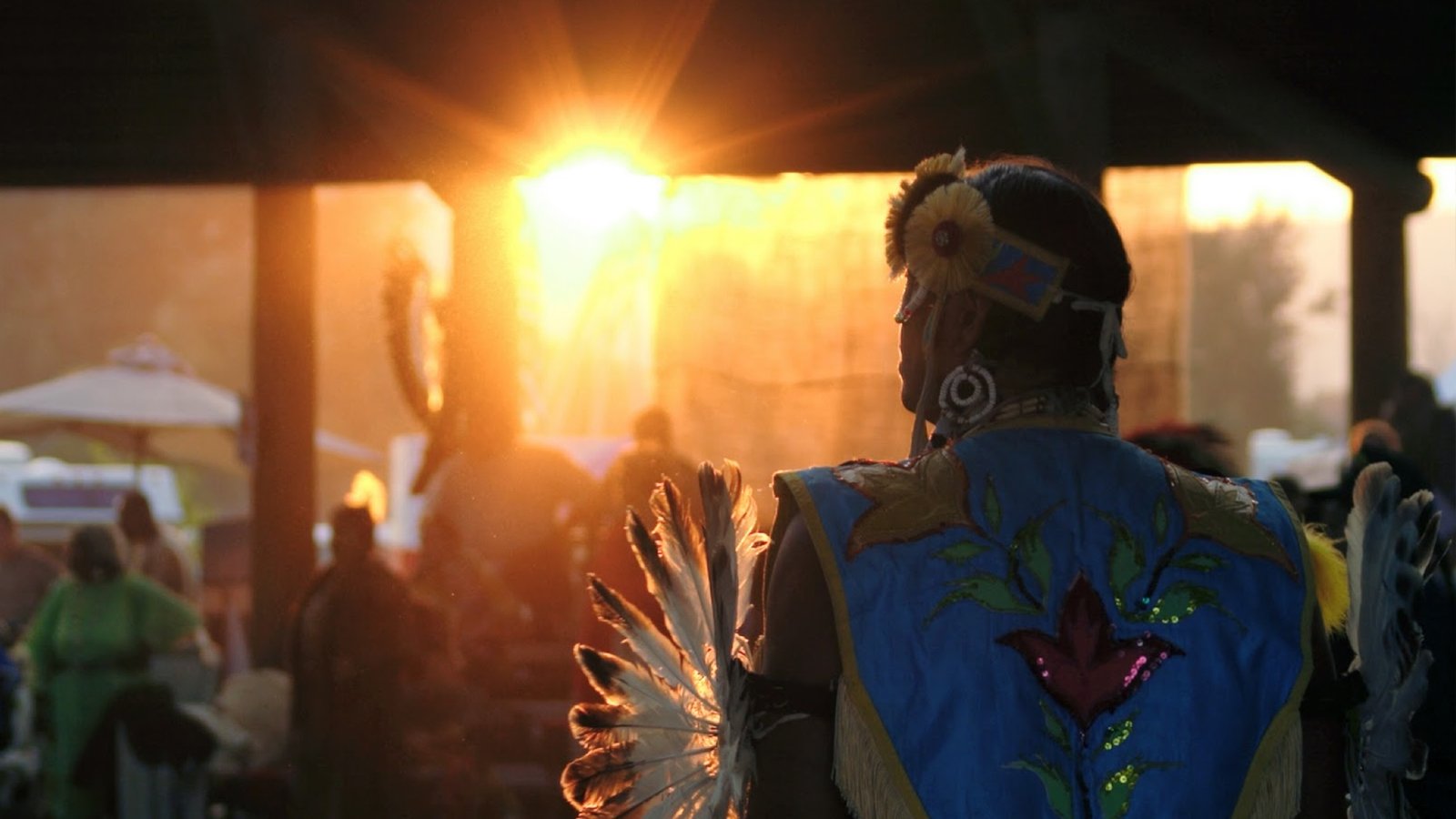 Male dancer in Native dance regalia, facing the sunset