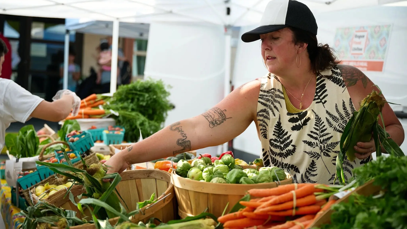 Vendor at a farmer’s market with vegetables
