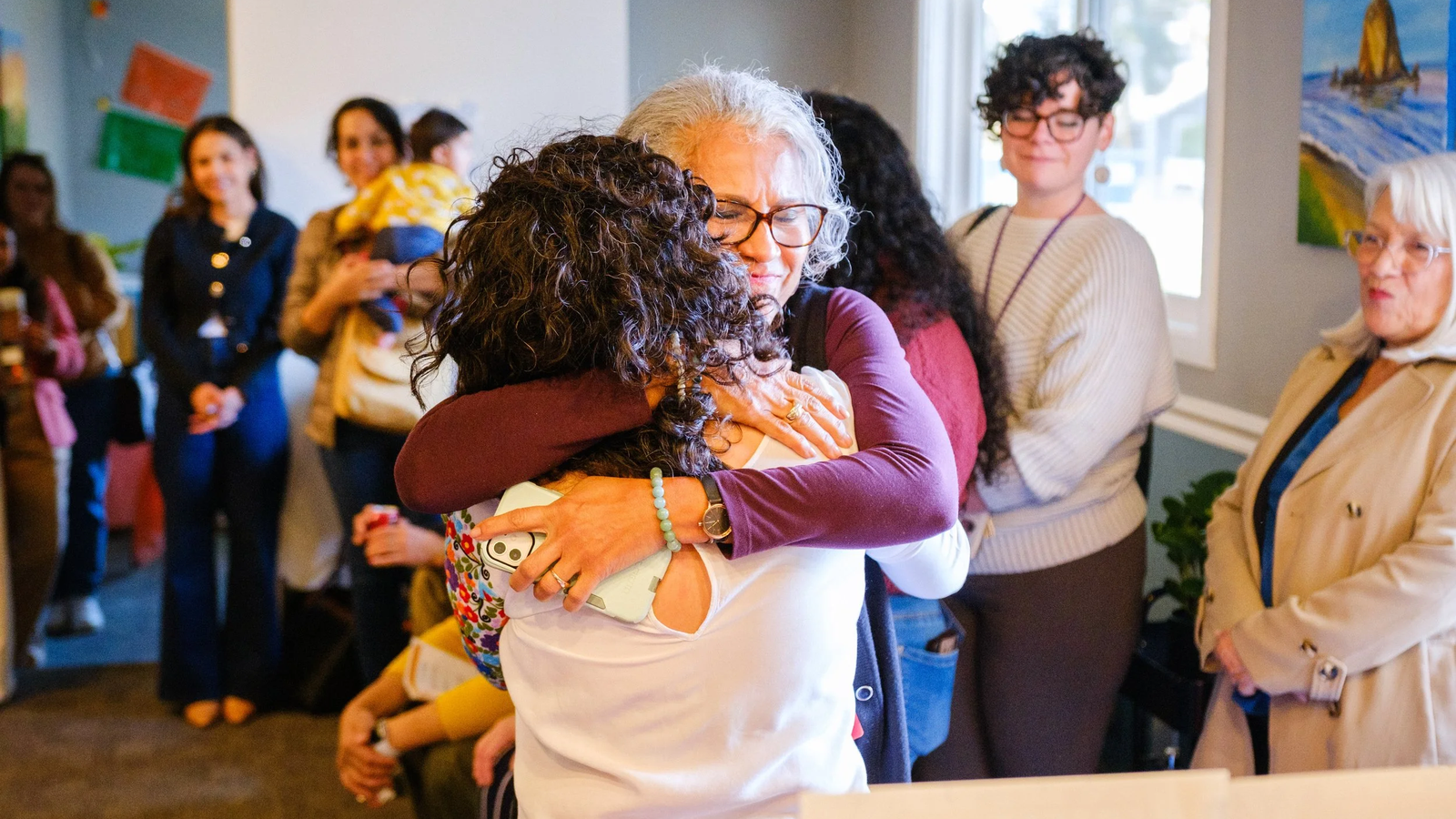 Two people hugging at a Raíces meeting