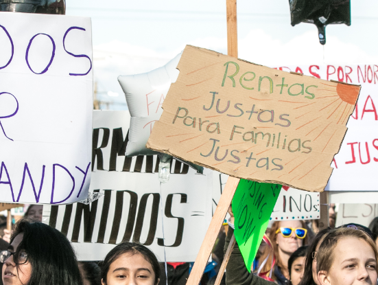 Young people with social justice signs in Spanish
