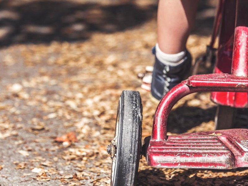 Closeup of a child’s foot on a tricycle