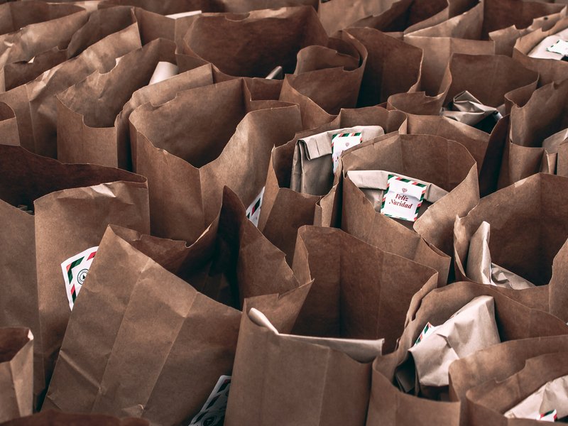 Food distribution bags, one tag reading “Feliz navidad” is visible