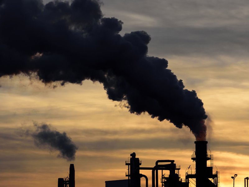 Smokestacks at a refinery, sunset