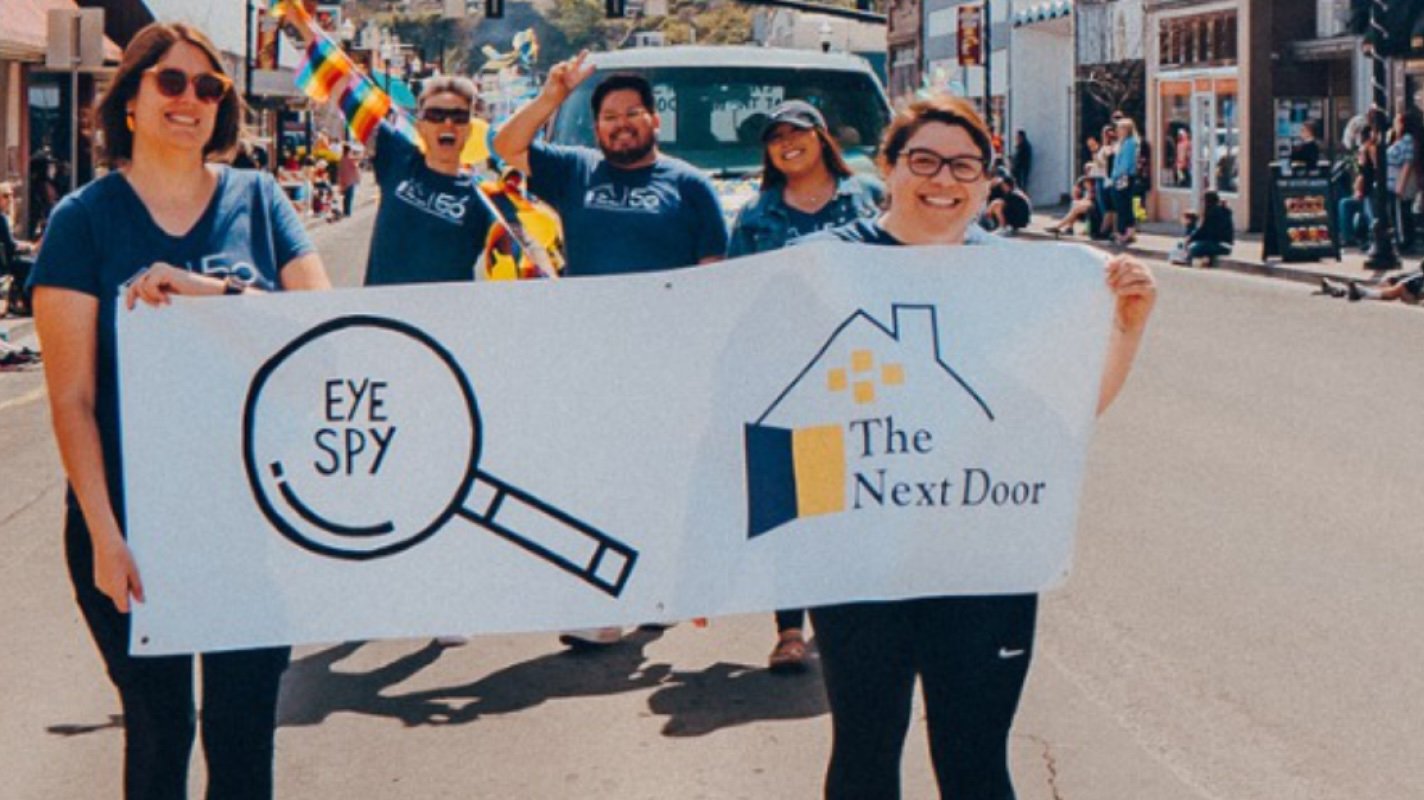 Volunteers for The Next Door in a parade, holding a banner