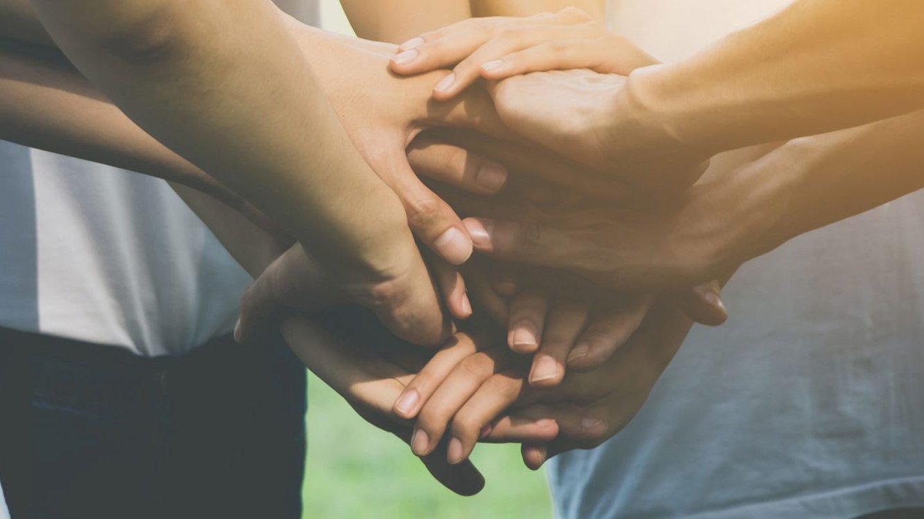 Closeup of a “hands in” gesture with several people in a huddle