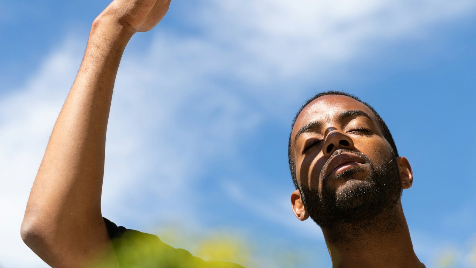Young Black man shielding his face from the sun