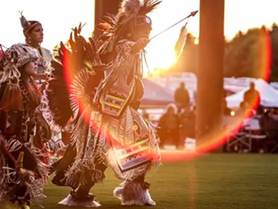 Native people in fancy dress doing a traditional dance