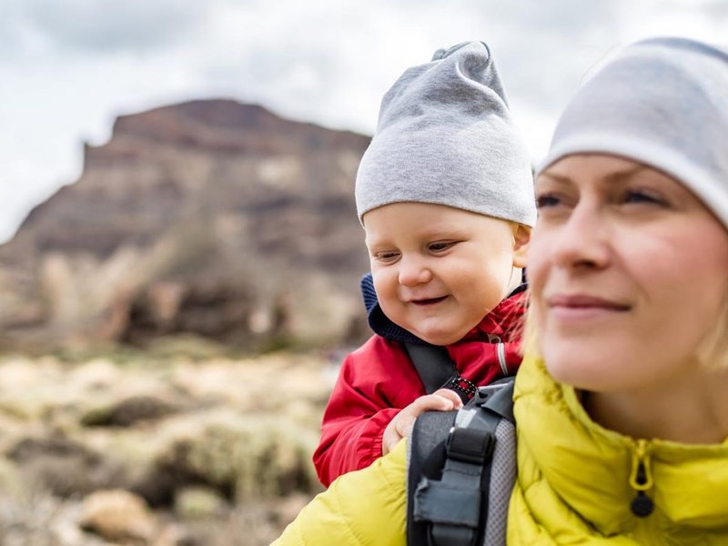 Woman hiking with a child in a backpack